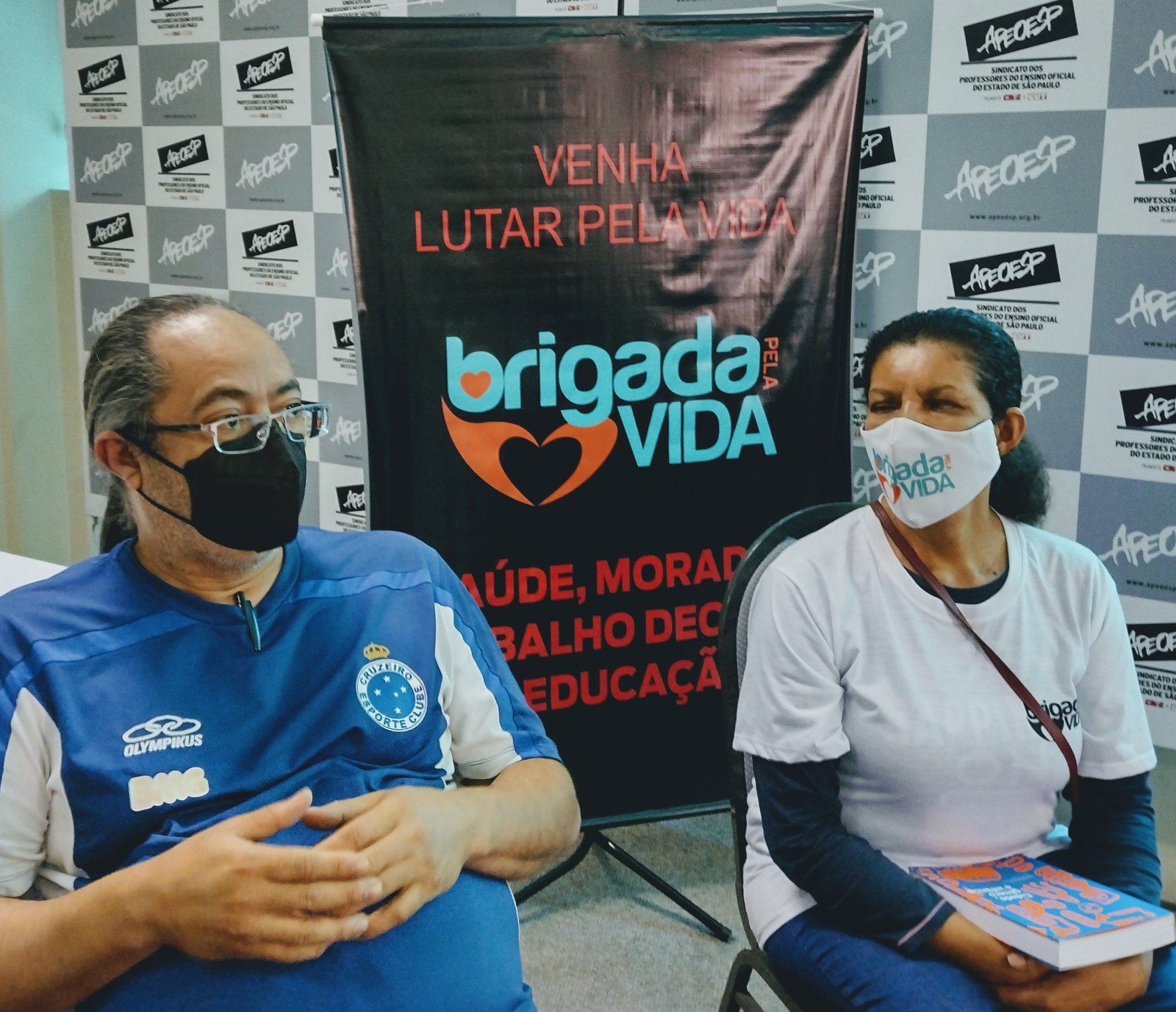 PROFESSOR JUSCELINO E NEIDE COM BANNER DA BRIGADA AO FUNDO